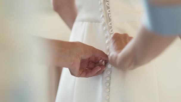 クロップ認識できない人の手ボタン花嫁のエレガントな白いドレスのコサージュ — ストック動画