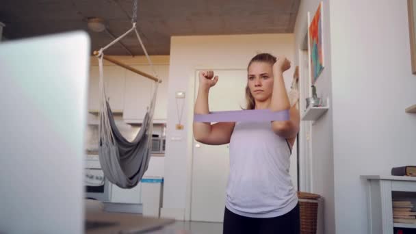 Αθλητική Γυναίκα Εκτελεί Ασκήσεις Όπλων Μπάντες Αντίστασης Ενώ Βλέποντας Tutorials — Αρχείο Βίντεο