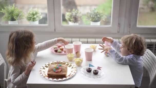 Side Näkymä Iloinen Pikku Lapset Rento Vaatteita Istuu Puupöydässä Lähellä — kuvapankkivideo