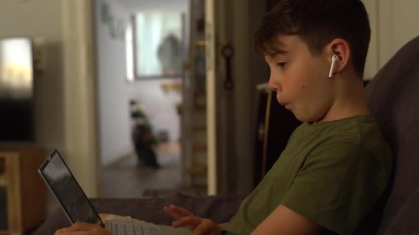 Veselý Malý Chlapec Pravých Bezdrátových Sluchátkách Mává Rukou Zatímco Chatuje — Stock video