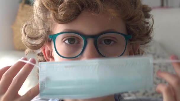 Αγόρι Ιατρική Μάσκα Και Γυαλιά Κοιτάζοντας Την Κάμερα Ενώ Περνούν — Αρχείο Βίντεο