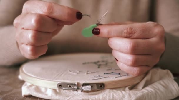 ミステリー無名の女性でカジュアル服糸針のために縫製作業しながら座ってテーブルでライトスタジオ — ストック動画