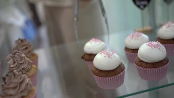 Περικοπή Ανώνυμη Γυναίκα Πωλητής Λαβίδες Λαμβάνοντας Νόστιμα Cupcake Λευκή Κρέμα — Αρχείο Βίντεο