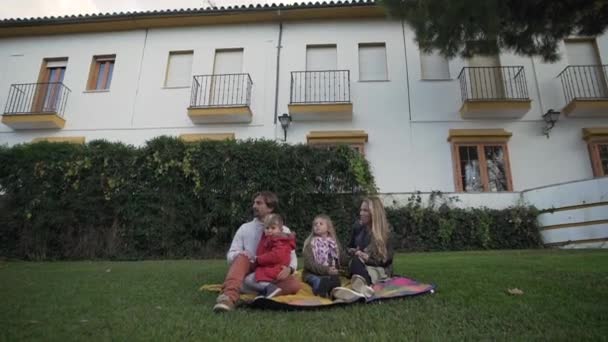 Família Feliz Com Crianças Pequenas Sorrindo Sentado Gramado Verde Perto — Vídeo de Stock