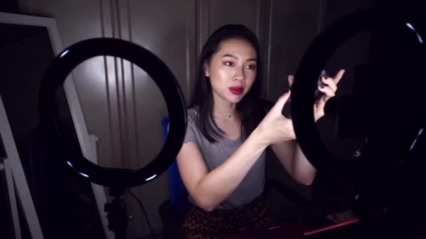 Giovane Blogger Asiatica Positiva Con Trucco Brillante Dimostrando Obiettivo Fotocamera — Video Stock