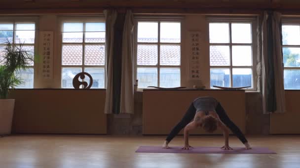 Kvinna Stående Barfota Prasarita Padottanasana Och Utövar Yoga Rymlig Studio — Stockvideo