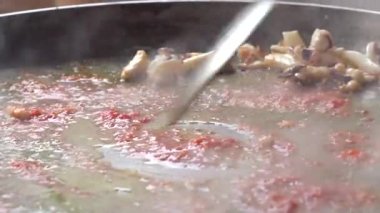 İsimsiz aşçı mutfakta kızartma yiyerek tavaya balık ekliyor.