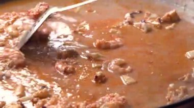 Geleneksel paella pişiren yüzsüz şef.