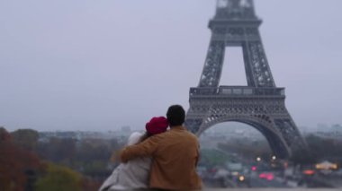 Tanımlanamayan bir çiftin, Paris 'in kasvetli günlerinde sisle kaplı ünlü Eyfel Kulesi' ne bakışları.