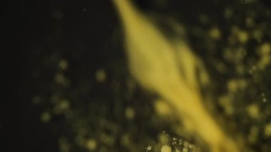 Üstten görünen soyut mavi ve turuncu mürekkep daireleri bulanık renkli saydam yüzey üzerine yerleştirilmiş.