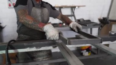 Fabrikadaki tezgahta çalışırken kaynak makinesi kullanan tanınmayan bir erkek kaynakçı.