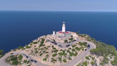 Kavisli yolu olan kayalık deniz kıyısındaki deniz feneri.