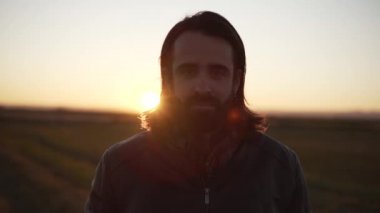 Adam sahanın ortasında duruyor ve kameraya bakıyor.