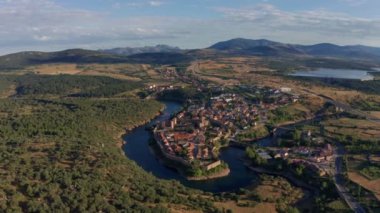Buitrago del Lozoya 'nın dolambaçlı nehir ve otlaklarla çevrili eski bir kasabasının insansız hava aracı görüntüsü