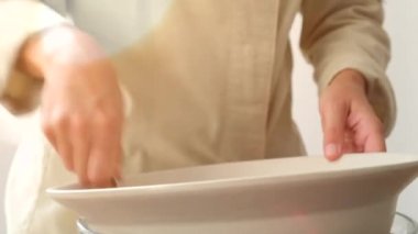 Tanınmayan şefin yüksek açılı hardal çırpması ve mutfakta tartar bifteği için iştah açıcı sos pişirmesi.