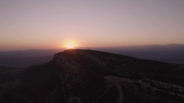Aerial view of picturesque landscape of mountainous valley against colorful sky with sun setting over horizon