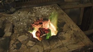 Zanaatkar atölyesinde alevlerin üzerine yerleştirilen metal detaylarına göre yüksek açılı yakınlaştırma