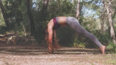 Yaz aylarında yeşil ormanda tek başına aktif kıyafet eğitimi alan genç bir kadın vücudu.