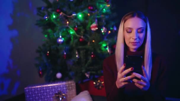 Счастливая Молодая Женщина Просматривает Мобильный Телефон Смеется Сидя Рядом Украшенной — стоковое видео