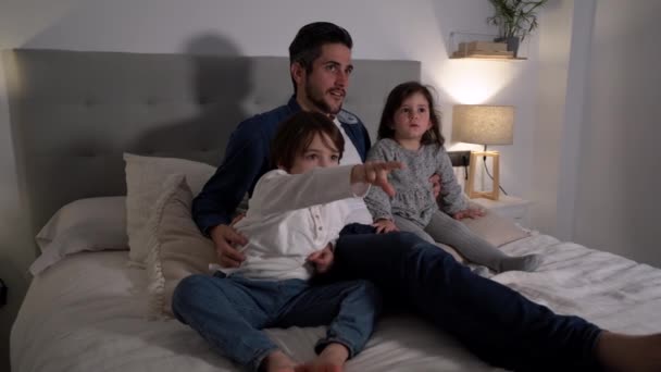 Padre Amoroso Sentado Cama Con Lindos Niños Pequeños Viendo Películas — Vídeo de stock