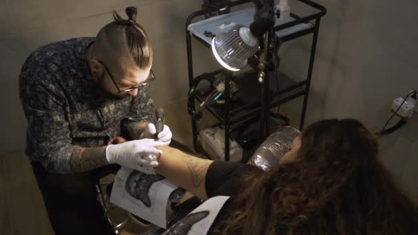 Joven Tatuador Masculino Usando Máquina Haciendo Tatuaje Con Tinta Negra — Vídeos de Stock