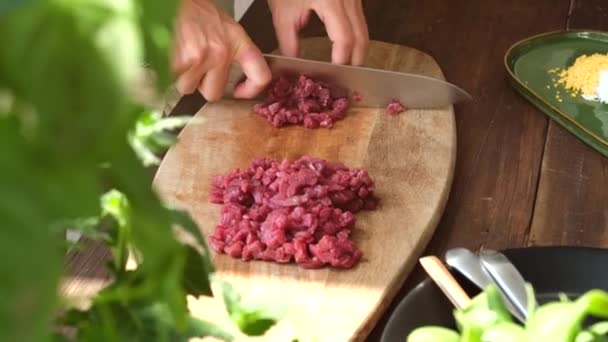 难以辨认的作物家庭主妇在家里做饭的同时 还在木制切菜板上切新鲜牛肉 — 图库视频影像