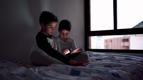 침대보에 침대에 형제들을 미소짓고 집에서 오락을 즐기면서 영화를 — 비디오