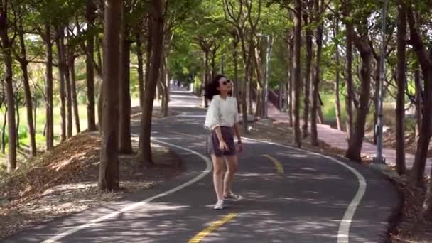 在Tanya Shen Green Bikeway 无忧无虑的女性 戴着太阳镜 一边微笑 一边看着相机 一边玩乐 — 图库视频影像