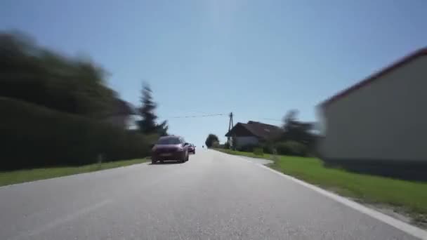 田舎のアスファルト道路を走る車のフロントガラスからの時間経過ビュー晴れた夏の日に農村部をリードするいくつかの交差点 — ストック動画