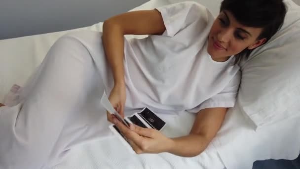 妊娠中の女性から現代の不妊診療所の病棟のベッドの上に横たわっている間 ソノグラム画像を検査 — ストック動画
