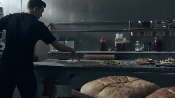 Szef Kuchni Metalową Łopatą Biorąc Tradycyjne Włoskie Surowe Pizzy Przygotowane — Wideo stockowe
