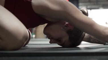 Sporcu kadın spor salonunda geriniyor.