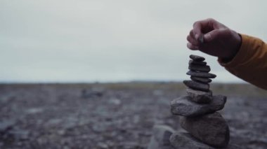 Heyecanlı adam yığınla taş düzenliyor.