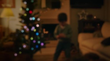 Akşamları Noel ağacı süsleyen çocuk