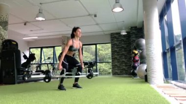 Güçlü kadın halterle egzersiz yapıyor.