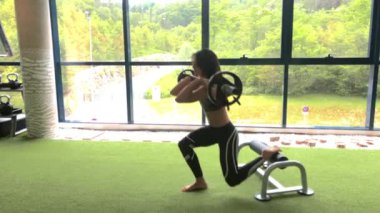 Güçlü kadın halterle egzersiz yapıyor.