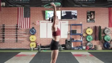 Halter plakalı çömelmiş bir kadın.