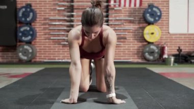 Sporcu kadın spor salonunda geriniyor.