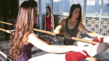 Genç dansçılar stüdyoda birlikte antrenman yapıyor, ısınıyor ve gün ışığında esniyorlar.