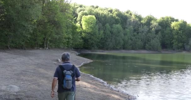 一个老年人走过湖面的背影 — 图库视频影像