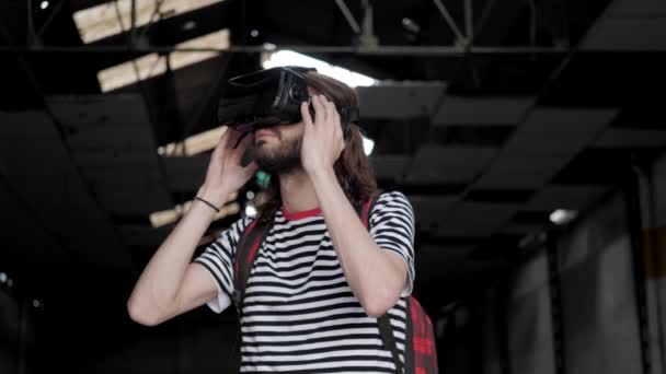 Интересный Молодой Мужчина Очках Виртуальной Реальности Показывает Исследует Заброшенный Склад — стоковое видео