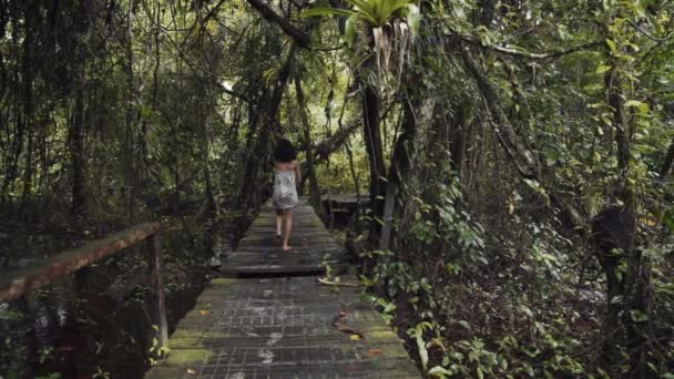 熱帯雨林の間の歩道に身を包んだ若い女性 — ストック動画