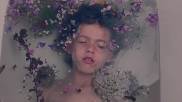 Beeldmateriaal Van Een Jongetje Een Bad Met Bloemen — Stockvideo