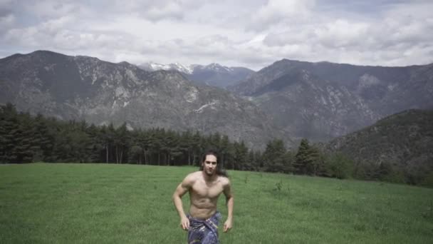 男人赤身裸体在岩石旁的草地上奔跑 — 图库视频影像
