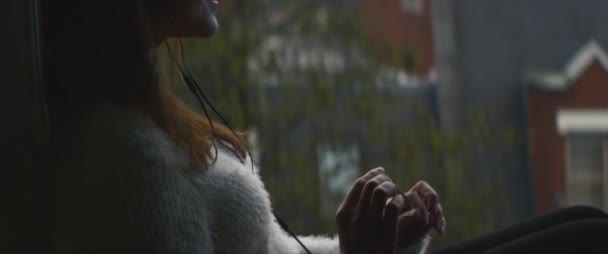 Drömmande Avslappnad Kvinna Lyssnar Musik Medan Sitter Bredvid Fönstret Med — Stockvideo