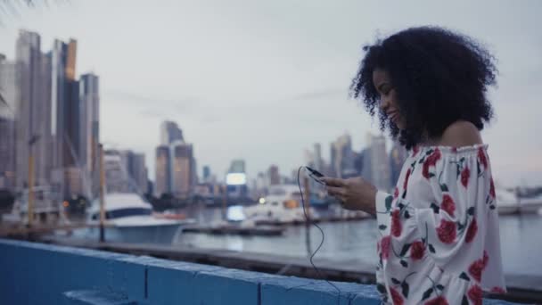 Wanita Tersenyum Dengan Earphone Menggunakan Smartphone — Stok Video