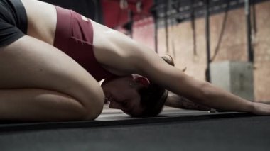 Sporcu kadın spor salonunda geriniyor.