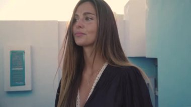 Modern mavi ve pembe bina üzerinde duran kadın