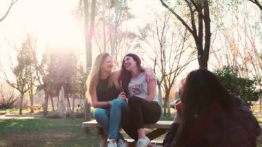 Genç bir kadın parkta oturan arkadaşlarını vuruyor.