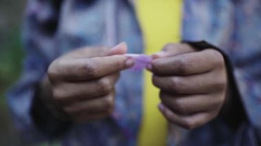 Siyah kız doğada menekşe yaprağı oynuyor.